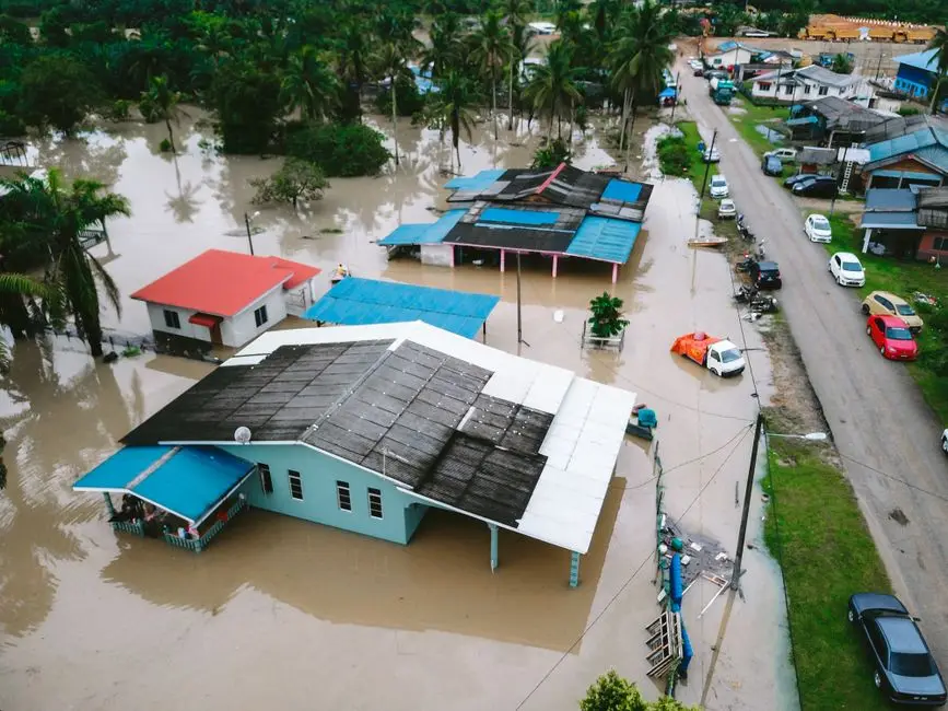 Aerial view of a flooded village in Kijal, Terengganu, Malaysia, showcasing submerged houses and streets.